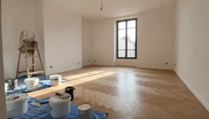 Appartement en cours de rénovation avec parquet neuf posé et outils de chantier, lumière naturelle dorée